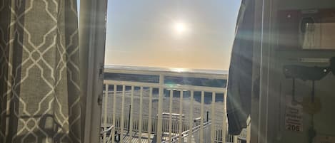 A window with a view of a beach and a parking sign.