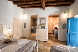 A bedroom with a bed, bedside table, wardrobe, and a bathroom visible through an open door. - Gavrion s Nest - Perfect for Families - Couples (Andros)