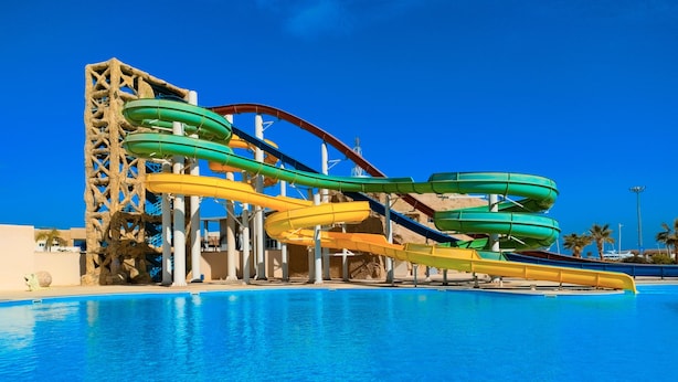 A water park with multiple water slides over a pool.
