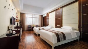 A hotel room with two beds, a desk with a coffee maker, a TV, and a large window with curtains. - Yunchao International Hotel Danzhou (Danzhou)