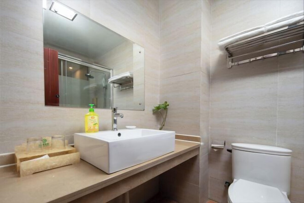Een badkamer met een wit wastafelmeubel, spiegel en toilet.