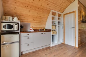 A compact kitchen with a microwave, toaster, and refrigerator.