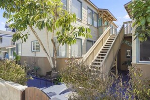 Enjoy a peaceful retreat with a balcony overlooking lush surroundings and a convenient staircase to the upper level.