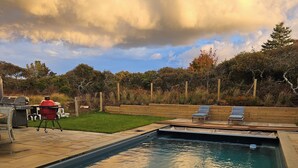 A swimming pool with a wooden deck, a barbecue grill, and lounge chairs. - Beautiful 4 bed with Pool + Spa (Nantucket)
