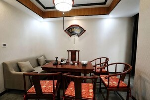 A dining area with a round table, chairs, and a sofa.