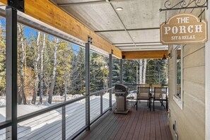 A covered porch with a wooden ceiling, metal railings, and a grill. - Fun Amok - Warren Wagon Rd - WiFi - Large driveway - Hot tub (McCall)