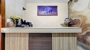 Taulell de recepció amb una fotografia d'un rinoceront emmarcat, un vas amb flors i una estàtua decorativa.