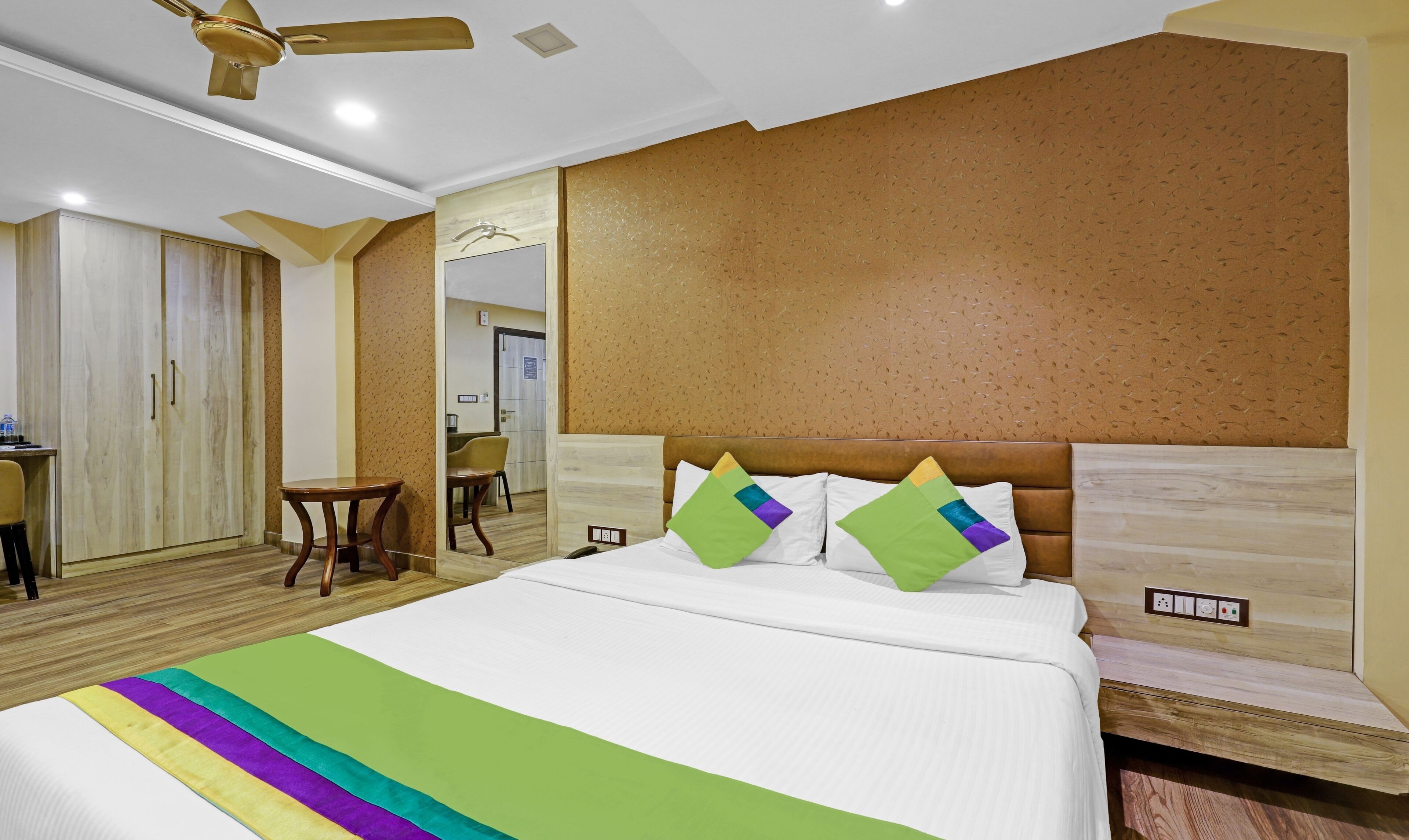 A hotel room with a bed, a desk, and a chair.