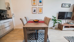 Un comedor con una mesa de madera, cojines estampados y un alfombra con diseño de cebra.