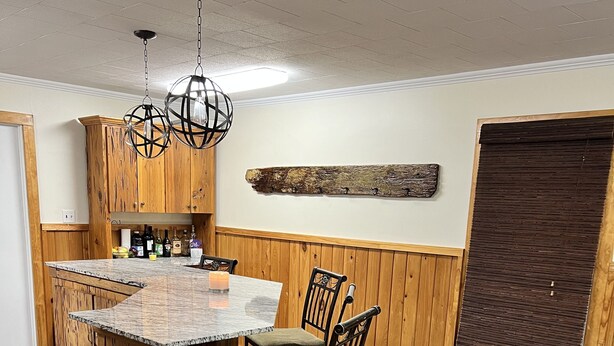 A kitchen with wooden cabinets, a marble island, and a bar area. - Drive up & park 6 ft from this clean, equipped houseboat in Cypress Cove Marina (Buras)