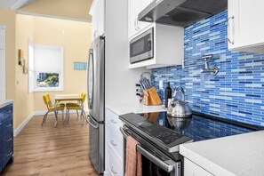 A modern kitchen with a stainless steel refrigerator, a microwave, and a kettle on the counter. - Oceanfront Beach House overlooking the Boardwalk (Santa Cruz)