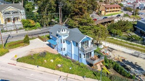 A two-story house with a balcony, a garage, and a driveway. - Oceanfront Beach House overlooking the Boardwalk (Santa Cruz)
