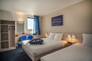 Ein Hotelzimmer mit zwei Betten, einem Schreibtisch, einem Stuhl, einem Kleiderschrank und einem Vorhangfenster.