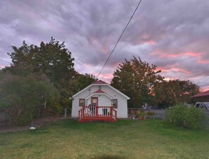Ein Bungalow mit roter Veranda und kleinem Vorgarten.