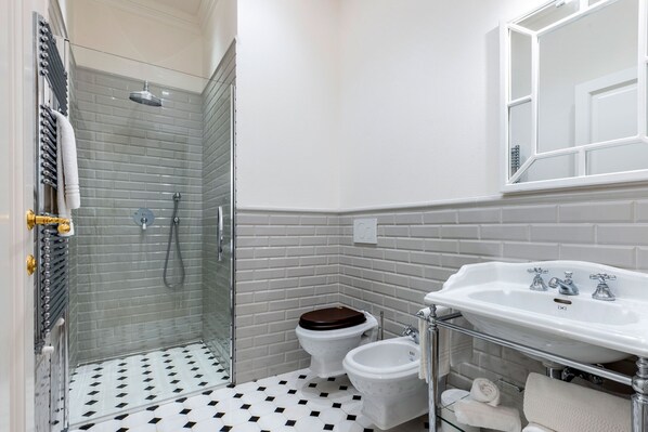 A bathroom with a shower, toilet, bidet, and sink. - Genteel Home Via della Spada (Florence)