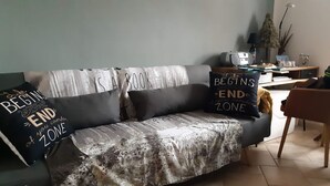 A living room with a sofa, two decorative pillows with motivational quotes, a small table with a lamp, and a potted plant. - Romantic house with swimming pool near Bologna & Florence CIN: IT047018C2OXJNJAB8 (Treppio)