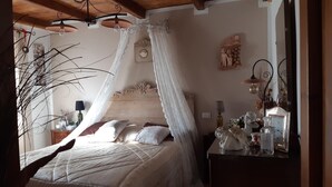 A bedroom with a canopy bed, a dresser with decorative items, and a mirror. - Romantic house with swimming pool near Bologna & Florence CIN: IT047018C2OXJNJAB8 (Treppio)