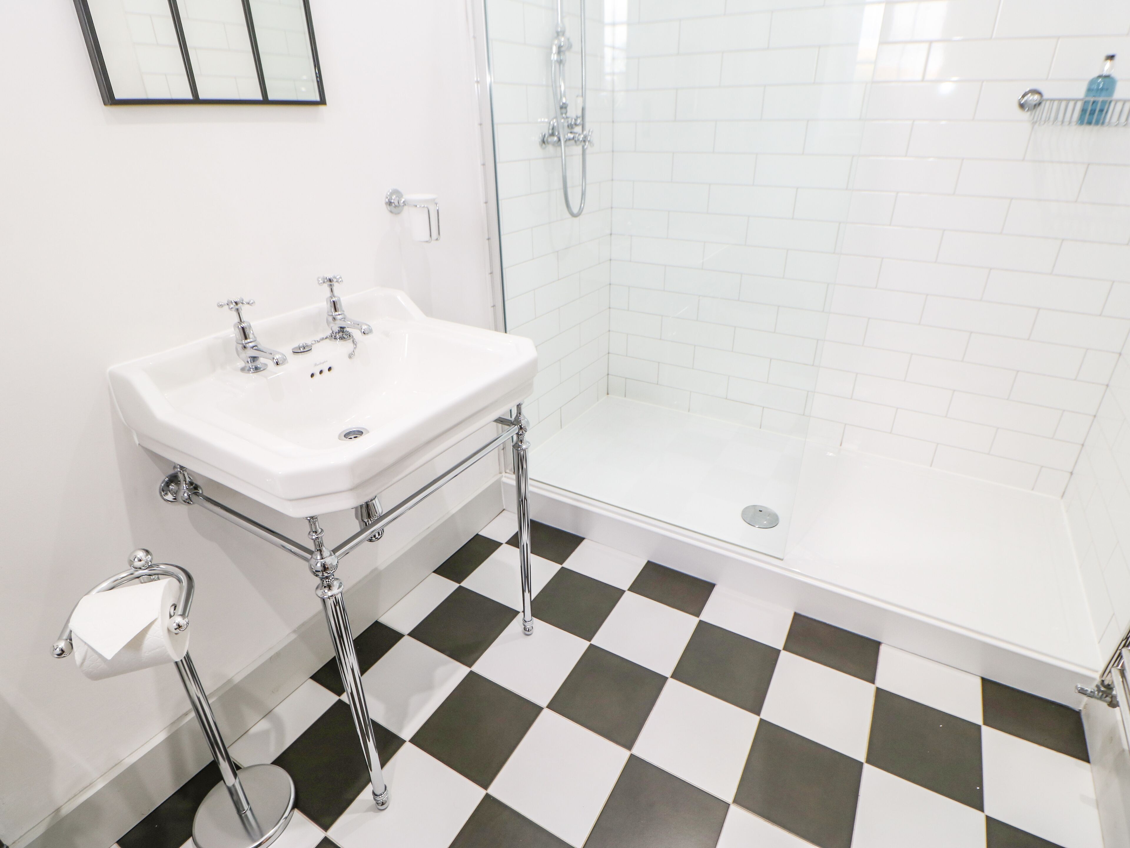 A bathroom with a white sink, a toilet, and a glass shower enclosure.