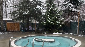Una piscina de diseño circular, rodeada por un solárium de hormigón.