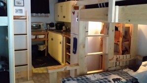 A compact room with a bunk bed, a desk, and a kitchenette. - Rural Maine cabin near Flagstaff Lake and Sugarloaf (Highland Plantation)