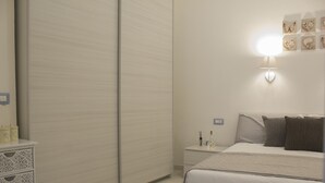 Une chambre à coucher avec un lit, une table de chevet et une armoire.