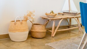 A room with a wooden table, a blue chair, and wicker baskets. - Coto Real 2359 Lovely apartment with sea view (Manilva)