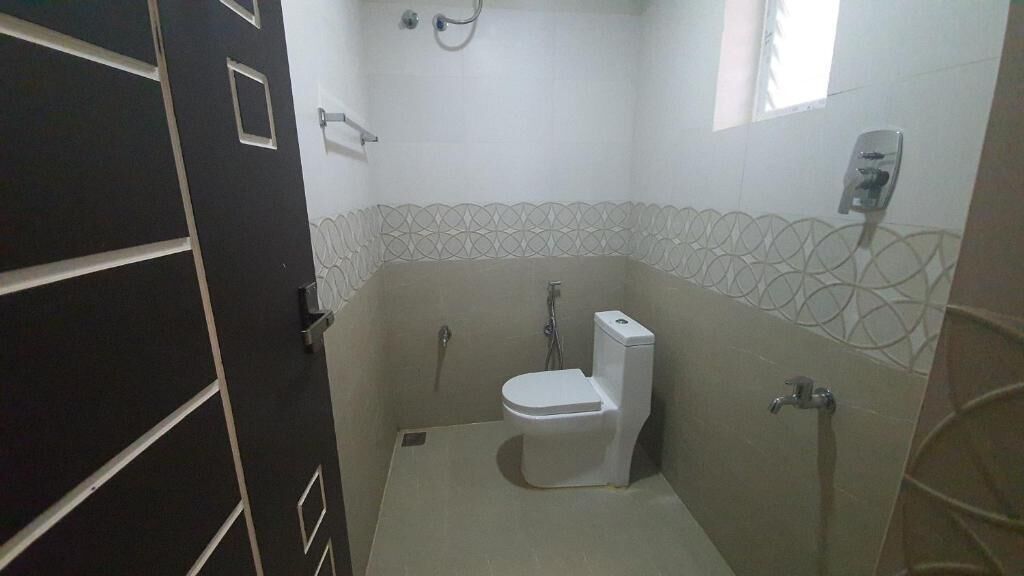 Une petite salle de bain comprenant des toilettes, une douche et un porte-serviettes.