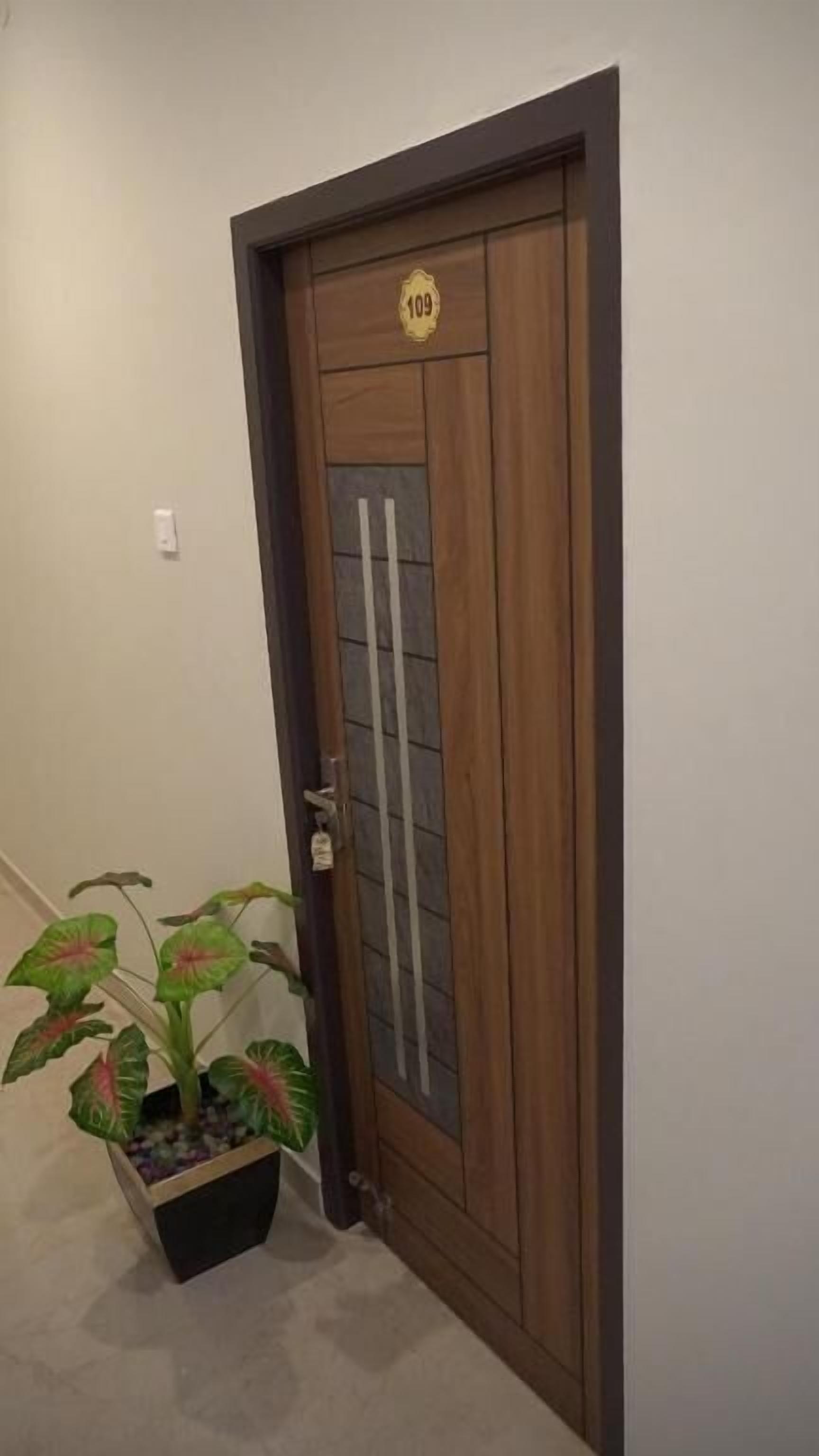 Una puerta de madera con un panel de vidrio y una placa con el número 109.
