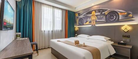 Ein Hotelzimmer mit Bett, Schreibtisch, Stuhl, einem Fenster mit Vorhängen und einem Wandbild eines Autos.