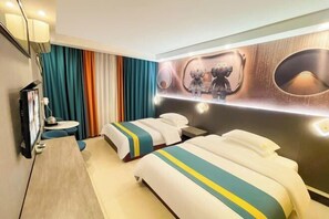 A hotel room with two beds, a desk, a chair, a TV, and a wall with a decorative mirror and wall art. - Jiangmen Danxia Hotel (Jiangmen)