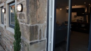 Edificio de piedra con una puerta que da a una cocina moderna.