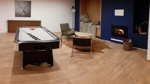 A pool table in a room with a fireplace, a radiator, and a framed picture on the wall.
