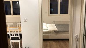 Une chambre à coucher avec un lit, une fenêtre, un radiateur et une chaise.