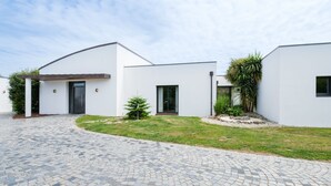 A modern two-story house with a paved driveway and a small lawn. - Spacious house with heated pool 7 minutes from the sea. (Les sables d olonne)