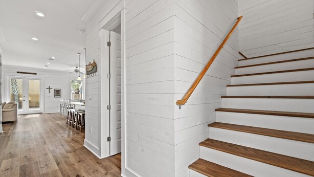 Un interior moderno con una escalera de madera, una zona de cocina y un espacio comedor.