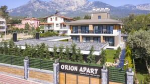 Un moderno complesso residenziale chiamato Orion Apart con vista sulle montagne sullo sfondo.