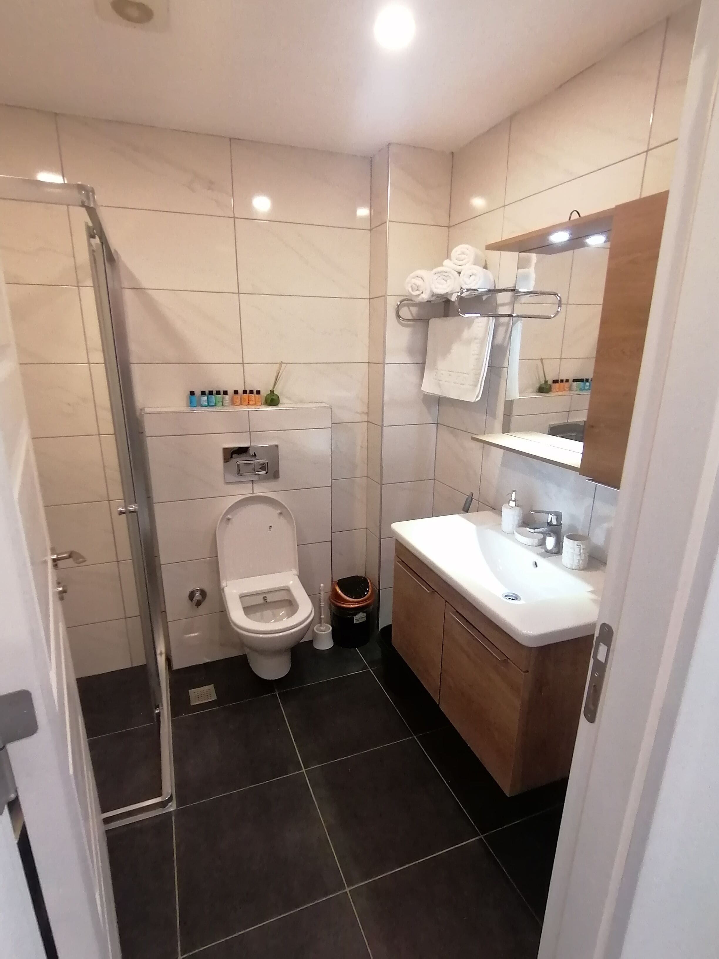 A modern bathroom with a toilet, sink, and shower.