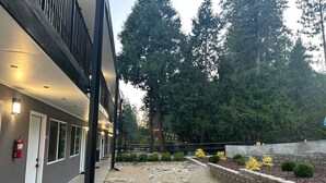 A building with a covered walkway, outdoor seating area, and a fire extinguisher. - Sierra Inn on the River (Kyburz)