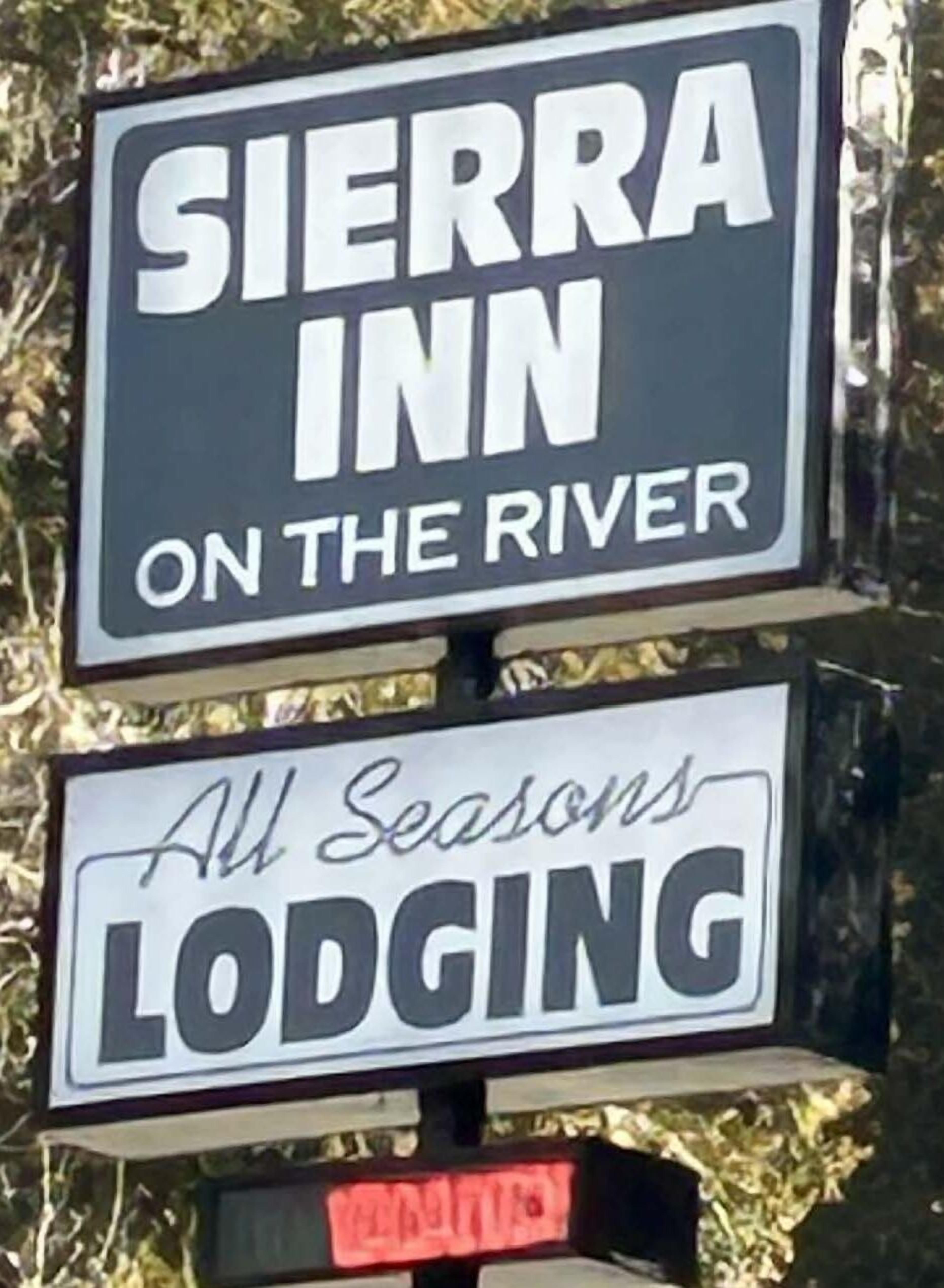 A sign for Sierra Inn on the River advertising All Seasons Lodging.