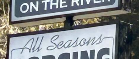A sign for Sierra Inn on the River advertising All Seasons Lodging.
