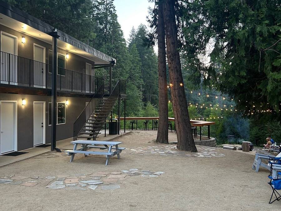Ein Gebäude mit einer überdachten Außenbereiches, Steinstufen und Picknicktischen.