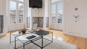 A modern living room with a glass table, two remote controls, and decorative bowls. - Lusitano's 2BDR Apartment in Alfama by LovelyStay (Lisboa)