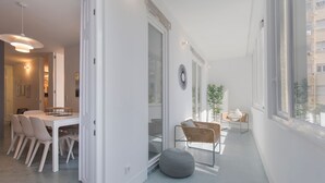 Ein modernes Interieur mit Essbereich, Sitzgelegenheiten und großen Fenstern.