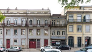 Uma fileira de edifícios com vários andares e arquitetura uniforme, com varandas e grandes janelas.
