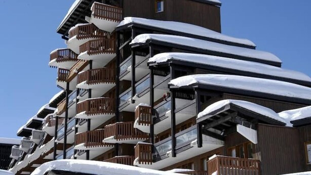 A multi-story hotel with balconies covered in snow, featuring a traditional architectural style with wooden railings. - NEW - ULTRA CENTER & PANORAMIC VIEW (Huez)
