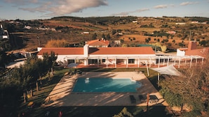 A modern villa with a swimming pool, outdoor seating, and a view of the surrounding countryside. - Vale Pisco - Villa Master (Carvalhal Bombarral)
