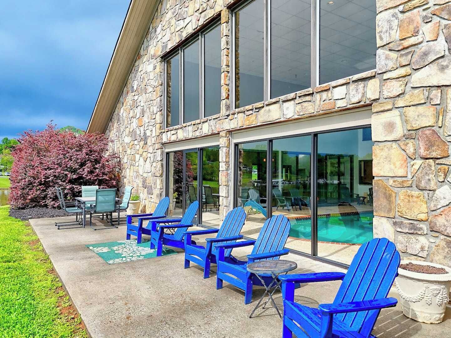 A stone building with a pool and outdoor seating area.