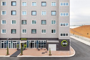 Egy modern dizájnnal rendelkező panzió, melynek homlokzata egyszerű, egyenletesen elhelyezett ablakokkal és központi bejárattal rendelkezik.