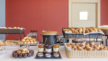 Een buffet met diverse gebakjes, brood en toevoegingen.