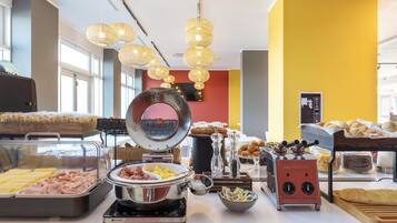 A breakfast buffet with various food items and cooking appliances.